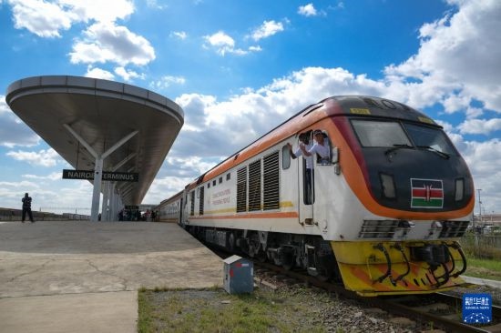 5月31日，在蒙內(nèi)鐵路內(nèi)羅畢站，機車駕駛員蔣立平（右）和博爾在即將開往蒙巴薩的E2次列車上揮手致意。新華社記者 楊光 攝