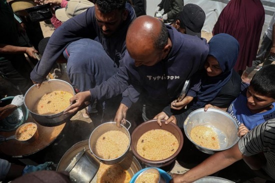 5月28日，人們在加沙城西部的沙提難民營領(lǐng)取救助食物。新華社發(fā)（里澤克·阿卜杜勒賈瓦德攝）