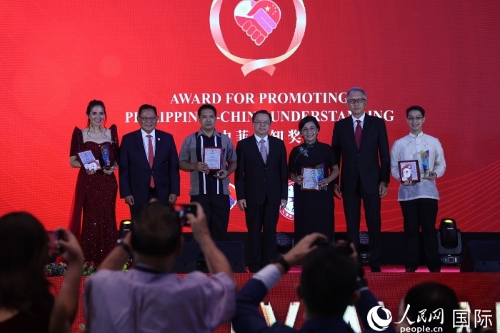 黃溪連大使和菲中了解協(xié)會主席與榮獲“友誼獎”的獲獎者合影留念。人民網(wǎng)記者 樊帆攝